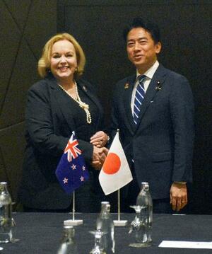 ニュージーランドのコリンズ国防相(左)と握手する小泉防衛相=2日、クアラルンプール(共同)