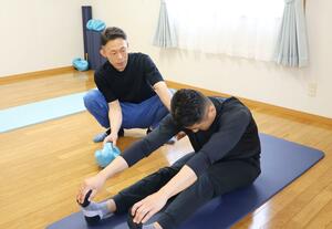 ピラティススタジオ「Ｂｌｕｅ」で指導にあたる石塚充さん（左）＝佐渡市小木町