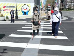 間隔が広がった横断歩道を渡る視覚障害者ら＝８日、新潟市中央区