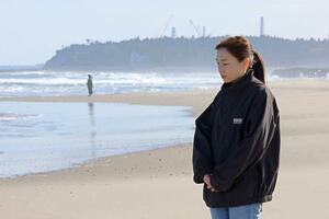 東日本大震災の発生時刻に海に向かって黙とうする長沼朱音さん＝１１日、福島県浪江町