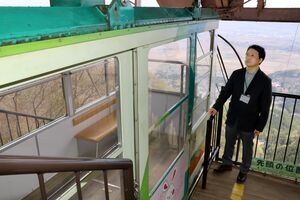弥彦山の山頂駅に立つ、弥彦観光索道新社長の赤塚宰さん。県内の周遊客を意識したもてなしに意欲を示す=弥彦村弥彦