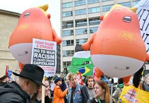 トランプ米大統領を赤ちゃんに見立てた風船と、抗議デモに参加する人々=17日、ロンドン(共同)