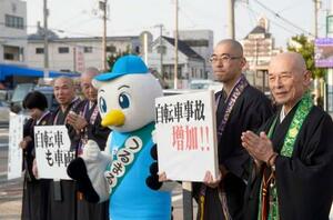 　自転車の青切符制度の周知や交通ルールの順守を呼びかける僧侶ら＝１３日午後、大阪市鶴見区