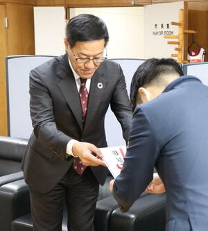 カーブミラーの目録を滝沢亮市長へ手渡す三条信用金庫の白倉徳幸理事長(左)