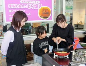 ガスコンロでどら焼きを調理する参加者=新発田市中央町3