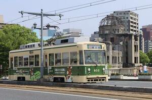 原爆ドーム(右奥)の近くを走る広島電鉄の路面電車=13日午後、広島市中区