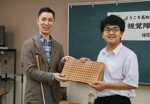 盲学校などに「アイゴ」の寄贈を行っている柿島光晴さん(左)=5月、高知市