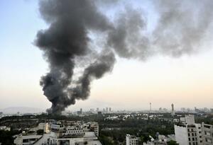 イスラエル軍による攻撃を受け、黒煙を上げるイラン国営テレビ本部=16日、テヘラン(共同)