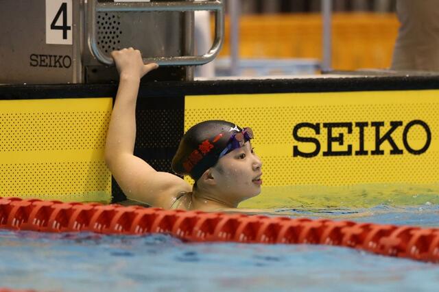 
女子５０メートル自由形決勝　優勝した橋本志保（新潟第一）がゴール後に電光掲示板を確認する＝１９日、長岡市のダイエープロビスフェニックスプール
