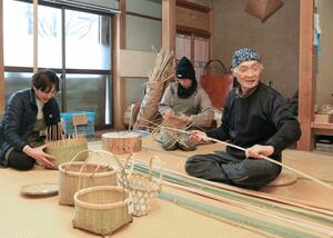 竹ひご作りやかごの編み方を入門者に教える葛綿慎さん(右)=長岡市上塩