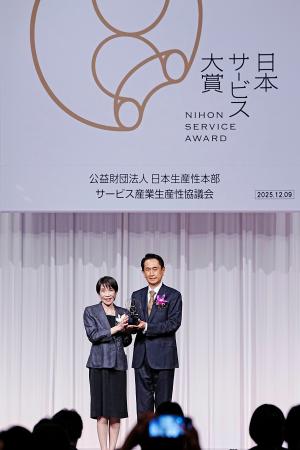 「日本サービス大賞」の表彰式で、内閣総理大臣賞を受賞したナビタイムジャパンの大西啓介社長(右)と記念写真に納まる高市首相=9日午後、東京都内のホテル