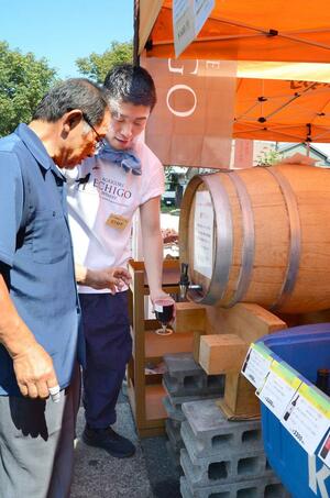 スタッフがたるから直接グラスに注いで提供した祭り限定の赤ワイン=南魚沼市浦佐