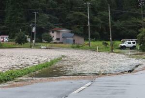 大雨の影響で冠水した秋田市内の道路=2日午後2時45分