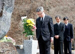 御嶽山噴火災害の慰霊碑と山頂に向かって黙とうする気象庁の野村竜一長官(手前)=28日午後、長野県王滝村
