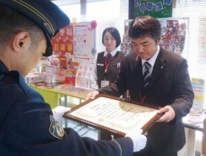 感謝状を受け取る塩沢郵便局長の小野澤宣博さん(右)=南魚沼市塩沢