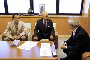 佐野恒雄町長(右)に田上町のご当地ソングについて語る西けんじさん(中央)と長橋正宣さん=田上町役場