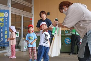 買い物客にティッシュを手渡し、施錠を呼びかける園児=6月10日、十日町市山本町5