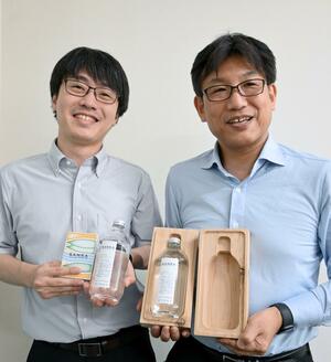 糸魚川産のスギを使ったクラフトジンを手にする猪又直登さん(右)ら=糸魚川市の糸魚川商工会議所