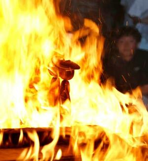 宮城県大崎市・鳴子温泉の神社で開かれた「こけし供養祭」で炎に包まれるこけし=5日午後