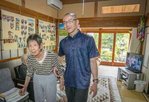 むつみ庵に入居する80歳代の女性に寄り添う日高明。「どこまで行くん」と女性に聞かれ「ちょっとアメリカまで」。軽妙なやりとりで散歩に連れ出した=2025年5月、大阪府池田市(撮影・京極恒太)