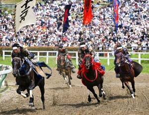 「相馬野馬追」の甲冑競馬で疾走する騎馬武者=24日午後、福島県南相馬市