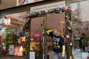 雑貨店「イレブン・イレブン」の店先に立つロシア人移民のアポリナリア・パホモバさん=2025年12月、セルビア・ベオグラード(共同)