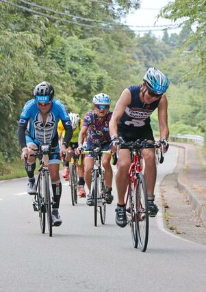 坂道や海岸線を自転車で颯爽と駆け抜ける選手たち＝９月１日、佐渡市