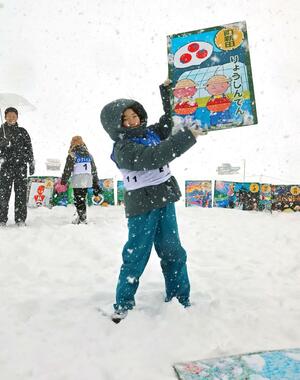 取った絵札を掲げて喜ぶ小学生=小千谷市平沢新田