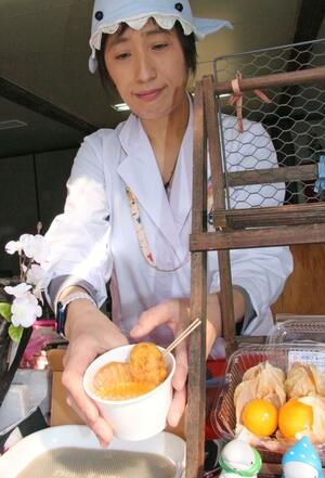 井部真理さんが観桜会会場で販売しているサメナゲットとホオズキのディップ=上越市の高田城址公園
