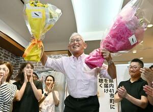 兵庫選挙区で当選を決め、花束を手に笑顔の泉房穂氏=20日夜、神戸市中央区