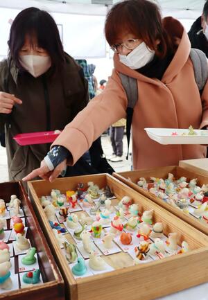福を求めてちんころを購入する来訪者=1月12日、十日町市本町6