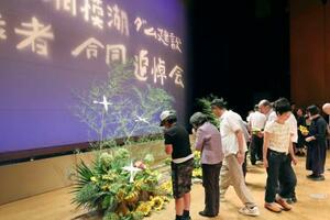 「相模湖・ダム建設殉職者合同追悼会」で献花する参列者=27日午後、相模原市緑区