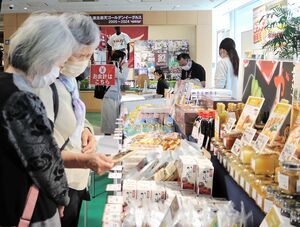 「佐渡島の金山」の世界遺産登録応援イベントで佐渡の特産品を品定めする来場者=5月16日、仙台市青葉区