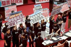 11日、台北の台湾立法院で野党の現金給付案に反対する与党、民進党立法委員ら(共同)