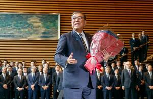 花束を手に記者団の取材に応じる石破茂首相=21日午後0時29分、首相官邸