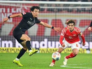競り合うボルシアMGの町野(左)とマインツの佐野海=マインツ(共同)