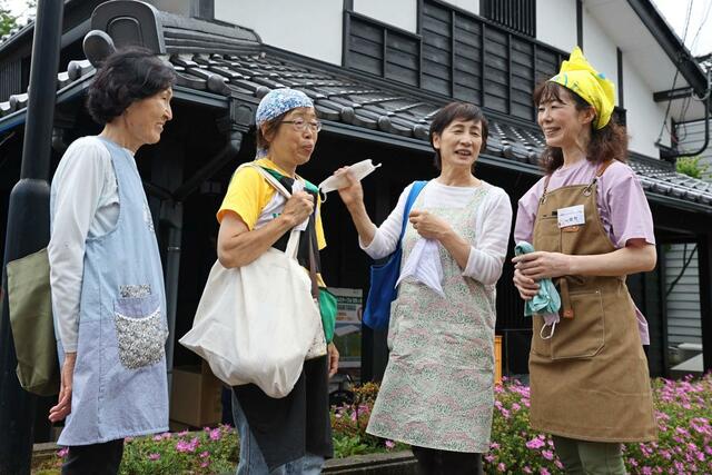 子ども食堂を手伝ってくれた被災者と語らう、ボランティア団体「チーム中越」代表の佐竹直子さん（右）＝６月３０日、石川県輪島市