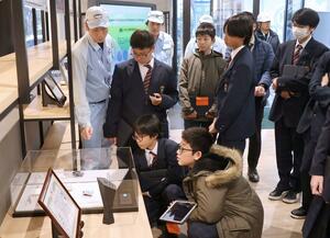 リケンNPRの工場見学で、担当者から説明を受ける第一中の1年生=柏崎市北斗町