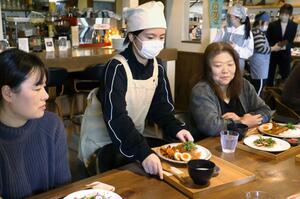 来店客にオリジナルカレーを提供する越前小の児童=新潟市西蒲区角田浜