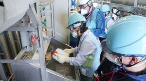 東電福島第1原発構内で、海水で希釈する前の処理水を採取する中国の専門家ら=17日(東電提供)