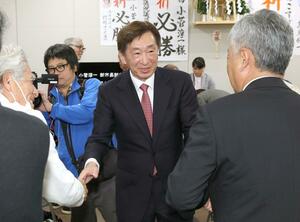 初当選を決め、支援者と握手を交わす小菅淳一氏。組織的な支援体制を整え、現職の中川幹太氏の批判票の受け皿となった=26日、上越市藤巻
