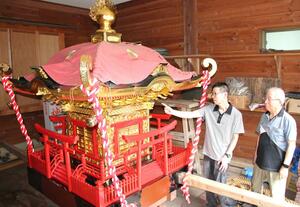 修繕したみこしの様子を確認する内田竜太郎さん(左)=妙高市関山の関山神社