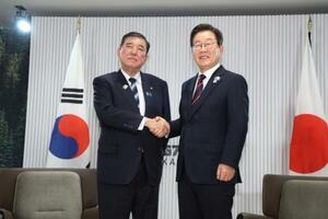 初の対面会談を前に握手する石破首相(左)と韓国の李在明大統領。「シャトル外交」を含め、緊密に意思疎通を推進する方針で一致した=17日、カナダ西部カナナスキス(共同)