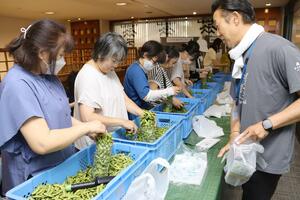 規格外の黒埼茶豆の詰め放題を楽しんだ買い物客ら=新潟市中央区東堀前通8