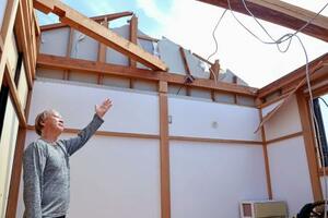 突風で自宅の屋根の大半が吹き飛ばされた松下和馬さん=6日午前10時23分、静岡県牧之原市