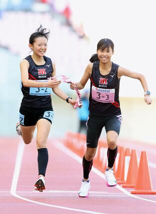 新潟明訓の２区篠澤葉（左）が３区山崎夢夏にタスキを渡す＝新潟市中央区