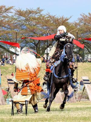 上杉謙信(右)の太刀を武田信玄が扇で受け止める名シーンを再現した「川中島合戦」=5月3日午後、山形県米沢市の松川河川敷(山形新聞社提供)