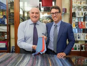 イタリア・ナポリのマリネッラ本店で、ネクタイを手にする3代目オーナーのマウリッツィオ・マリネッラさん。右は4代目のアレッサンドロさん=5日(共同)