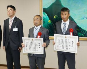 清田仁・県土木部長(左)から知事感謝状を受け取った早川伸二さん(右)と阿部比佐良さん=6月2日、県庁