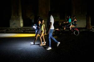 　キューバ・ハバナで、大規模停電の中、街を歩く人々＝１６日（ＡＰ＝共同）